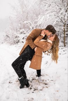 a man and woman kissing in the snow