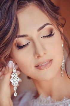 a beautiful woman with long hair and earrings on her head, posing for the camera