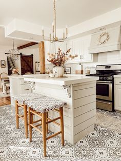 a kitchen with two stools in front of an island and a stove top oven