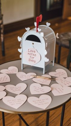 a table topped with lots of hearts and a mailbox filled with love notes on it