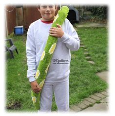 a young boy is holding a large green object