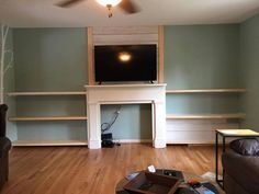 an empty living room with a fireplace and tv