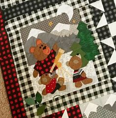 two teddy bears sitting on top of a black and white checkered table cloth next to each other