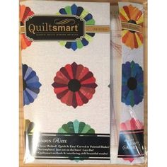 two quilts in a box with colorful flowers on them, one is white and the other is multicolored