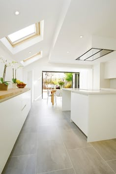 an image of a kitchen with skylights on the ceiling and white cabinets in the background