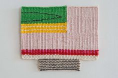 a piece of knitted material with different colors and designs on the top one side