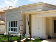 a house with white doors and windows in the front yard