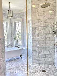 a white bath tub sitting inside of a bathroom next to a walk in shower stall