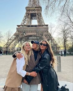 two women pose for a photo in front of the eiffel tower, paris