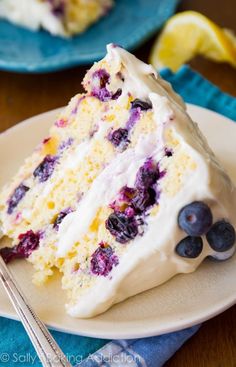 a slice of blueberry cake on a plate next to a fork and spoons