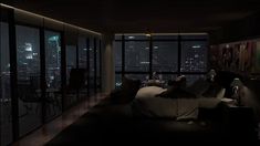 a bedroom with large windows overlooking the city at night