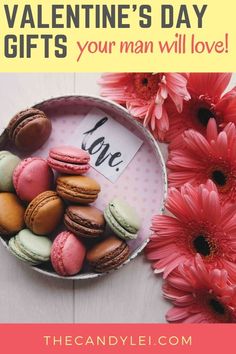 pink flowers and macaroons in a bowl on a white table with a love sign