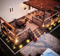 an overhead view of a patio and deck at night with lights on the railings