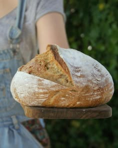 a close up of a person holding a loaf of bread