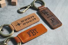 two leather keychains with the word fby on them