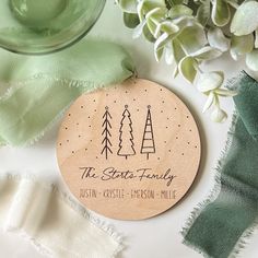 a wooden ornament with three trees on it next to some green napkins