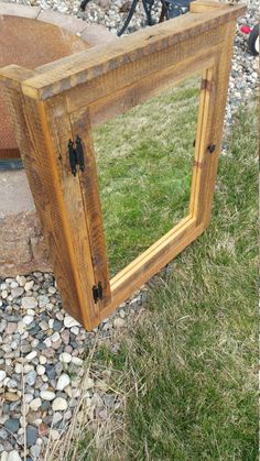 a mirror sitting on top of a grass covered field