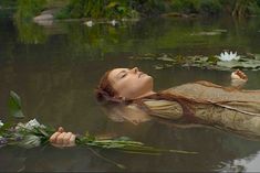 a woman floating in the water with flowers