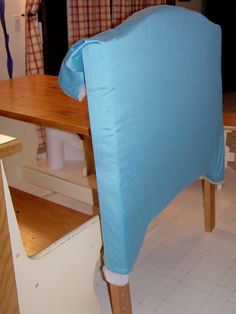 the back of a chair with a blue cover on it's head and legs