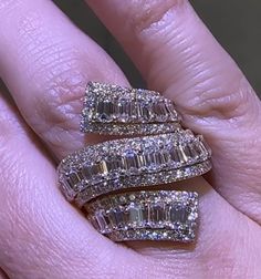 a woman's hand with three rings on top of her finger and two diamonds in the middle