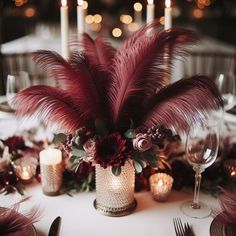 the centerpieces are adorned with red flowers and feathers, while candles stand in front of them