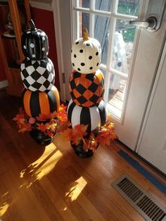 two pumpkins decorated with black and white checkers are sitting in front of a door