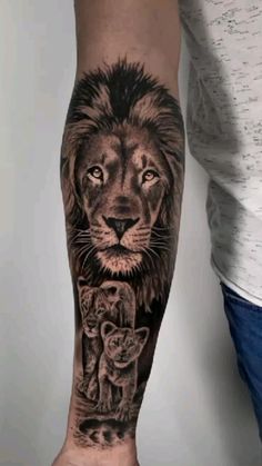 a man's arm with a lion and cat tattoo on the left side of his arm