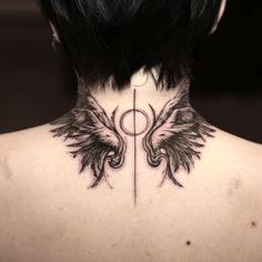 the back of a woman's neck with black wings and an inverted symbol on it