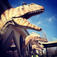 two large dinosaur statues in front of a building