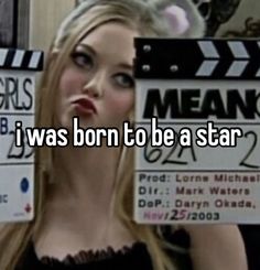 a woman holding up a sign that says i was born to be a star