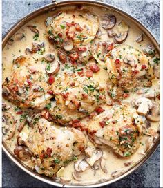 a pan filled with chicken and mushrooms covered in sauce