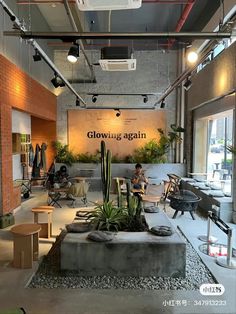 the inside of a building with people sitting at tables and chairs in front of it