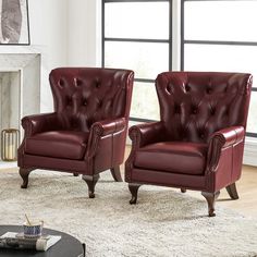 two red leather chairs sitting on top of a white rug