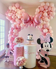 a minnie mouse balloon arch with balloons and decorations for a baby's first birthday