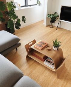 a living room filled with furniture and a flat screen tv on top of a wooden table