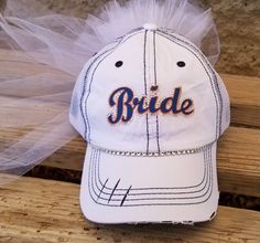 "Custom Bride Hat for Baseball Bachelorette Party or Bridal Shower- Customized to match her favorite team font and colors! I can match any team Makes a perfect gift for Bride! My Baseball theme Bride caps come with veil and customized in her favorite Baseball Team Colors. Perfect accessory to wear to a bachelorette party/bridal shower at a Baseball Game! Team Bride Hats also available message me for package deals@ OTHER BRIDE HAT STYLES AVAILABLE CLICK HERE https://www.etsy.com/shop/CapsbyKari?s Customizable White Hats For Sports Events, Customizable White Baseball Cap For Sports, Personalized White Trucker Hat For Sports Events, Personalized White Baseball Cap For Sports Events, Customizable White Trucker Hat For Sports Fans, Adjustable Customizable Sports Fan Hat, Customizable White Hats For Fan Gear, Baseball Bachelorette Party, Baseball Bachelorette