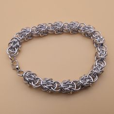 a silver chain bracelet on a tan background