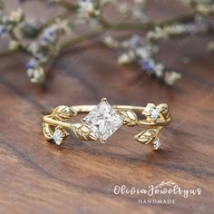 a close up of a ring on top of a wooden table with flowers in the background