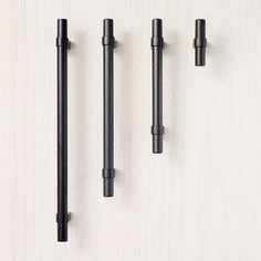 three black handles and two poles on a white surface