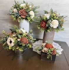 three vases filled with flowers sitting on top of a wooden table next to each other