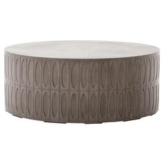 a round coffee table with an intricate design on the top and bottom, made out of concrete