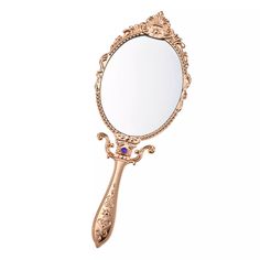 a mirror that is sitting on top of a white surface with an ornate design around it