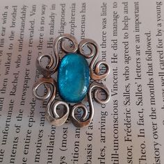 Very beautiful vintage art nouveau dress brooch. It has a striking turquoise blue cabochon at its centre  turquoise. It is set in a very art nouveau style swirling silver tone frame.  Definitely a statement piece. It will look fabulous on a scarf, coat or evening dress.   4.5 cm x 4 cm x 0.5 cm with trombone clasp which looks a bit twisted but works fine !! Price includes tracked shipping. Art Deco Blue Brooches For Gifts, Art Deco Blue Brooches As Gifts, Blue Cabochon Brooch For Formal Occasions, Formal Blue Cabochon Brooch, Antique Handmade Blue Brooches, Turquoise Cabochon Brooch For Gift, Turquoise Cabochon Brooch As A Gift, Art Nouveau Dress, Brooch Dress