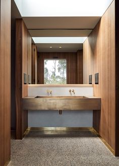 a bathroom with a large mirror and two sinks in the middle of it, next to a window