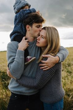 a man and woman hug each other in the middle of a field