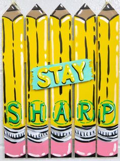 some yellow and pink pencils are next to a sign with the words stay sharp