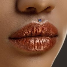 a woman's lips and nose with a diamond in the middle of her lip