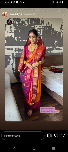 a woman standing in front of a bed wearing an orange and pink sari