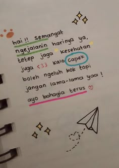 an open notebook with writing on it and a paper airplane in the middle that says, hoi i semangat ngai haing ya