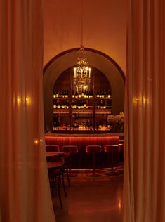 a dimly lit bar is seen through curtains